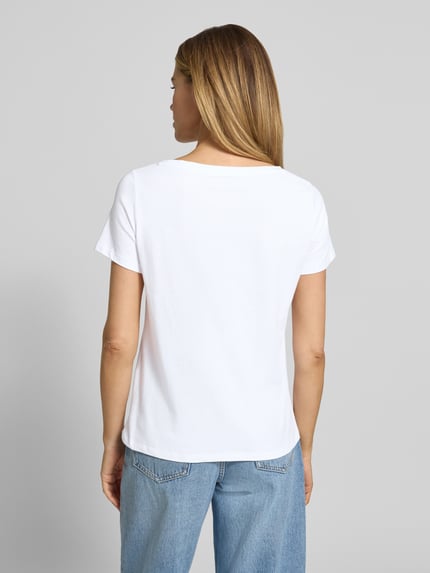 Modelka kobieca nosi Regular Fit T-Shirt mit Motiv-Print od More & More, biały elastyczny bawełniany materiał, krój regular fit, U-kształtny dekolt, długość pleców w rozmiarze 36: 60 cm, widok całej sylwetki od tyłu.
