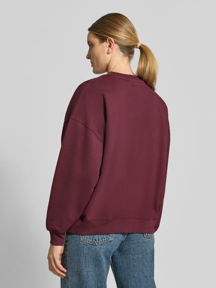 Männermodel trägt Oversized Sweatshirt aus Baumwolle von Anine Bing, bordeauxrot, Rundhalsausschnitt, elastische Abschlüsse, Label-Detail, Ganzkörperansicht Rückansicht, długość pleców w rozmiarze S: 61 cm