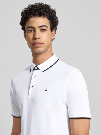 Męski model nosi Slim Fit Poloshirt mit Viskose-Anteil Modell 'Paulos' od Jack & Jones, bawełniany mix z wiskozą, krój slim fit, kołnierzyk polo, krótki rękaw, logo na piersi, długość pleców w rozmiarze M: 72 cm, widok na górną część ciała z przodu