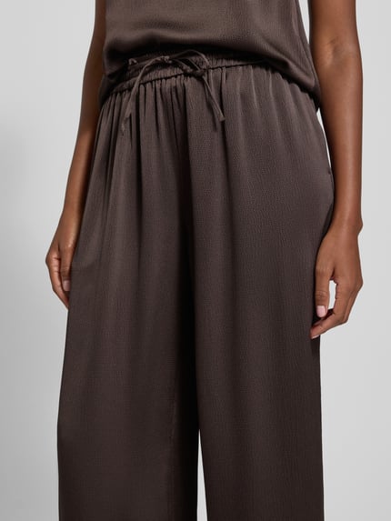 Frauenmodel trägt Stoffhose mit elastischem Bund Modell 'HELENA' von Samsøe Samsøe, Material-Mix mit Stretch-Anteil, lockerer Schnitt, Französische Eingrifftaschen, Nahaufnahme Oberkörper.