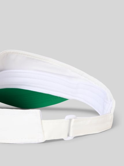 Produktfoto, detail van witte Schirmmütze met Logo-applicatie van Marc Cain, groene onderzijde van curved visor, klittenbandsluiting, motiefapplicatie