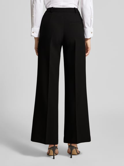Frauenmodel trägt Wide Leg Anzughose mit Viskose-Anteil Modell 'HASMINA' von HUGO, Optik: Unifarben, Passform: Wide Leg, Verschluss; Ganzkörperansicht Rückansicht.
