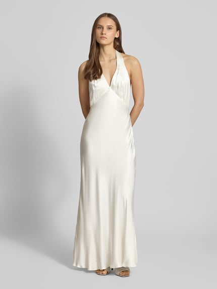 Frauenmodel trägt Abendkleid aus reiner Viskose mit Neckholder Modell 'THENA' von Bardot in cremefarbenem Satin, körpernahe Passform, Maxilänge, Ganzkörperansicht von vorne.