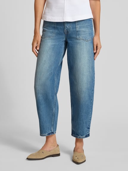 Frauenmodel trägt Straight Fit Jeans in verkürzter Passform Modell 'VEYRA' von Samsøe Samsøe aus Reine Baumwolle, 5-Pocket-Design, Knopf- und Reißverschluss, mittleres Blau mit sanften Wascheffekten, Bundweite 37 cm, Innenbeinlänge 71 cm, Ganzkörperansicht von vorne.
