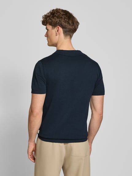 Männermodel trägt Regular Fit Poloshirt in Strick-Optik Modell 'Bray' von Blend, Reine Baumwolle, Kurzärmelig, Rückenlänge 68 cm, Ganzkörperansicht Rückansicht.