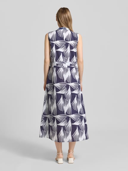 Frauenmodel trägt Hemdblusenkleid mit V-Ausschnitt und Bindegürtel Modell 'Lani' von GUIDO MARIA KRETSCHMER WOMAN aus Reine Baumwolle in A-Linie, Allover-Look mit Knopfleiste als Midikleid, Rückenlänge bei Größe 36: 128 cm, Brustweite: 48 cm, marineweißes Muster, glatte Textur, Ganzkörperansicht Rückansicht.