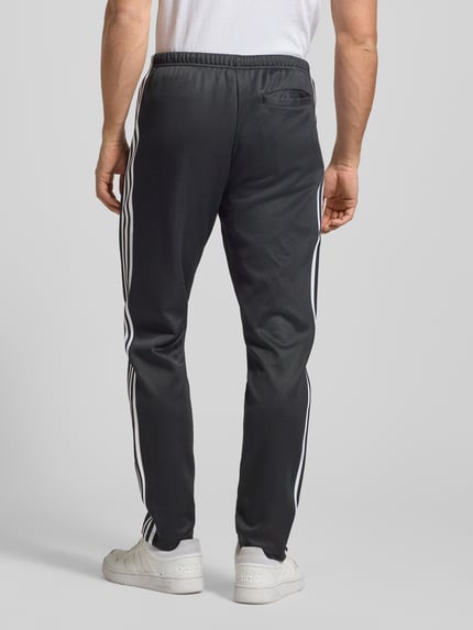 Męski model nosi Sweatpants mit elastischem Bund od adidas Originals, czarny kolor, bawełniany miks, luźny krój, widok z tyłu całej sylwetki.