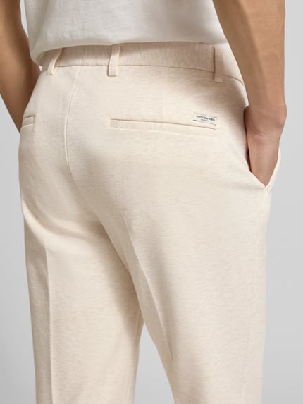 Mannenmodel draagt stoffen broek met bandplooien en Franse steekzakken van Scotch & Soda, katoenmix met stretch, detailopname heup.