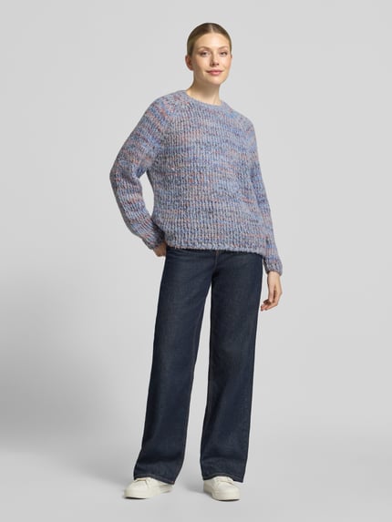 Frauenmodel trägt Strickpullover mit Rundhalsausschnitt von Smith and Soul, grob gestrickt, meliertes Muster in Blau-Lila, Regular Fit, Material-Mix mit Mohair-Anteil, kombiniert mit dunkler Jeans, Ganzkörperansicht von vorne.