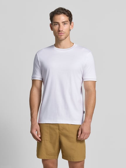Męskimodel nosi białą koszulkę Slim Fit T-Shirt aus reiner Baumwolle Modell 'Tessler 195' von BOSS, Męski t-shirt, całkowite ujęcie z przodu.