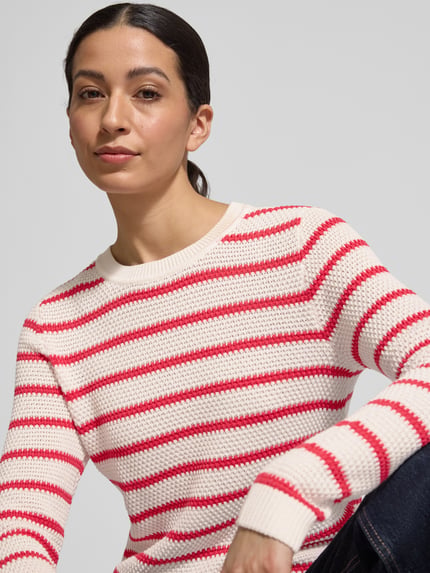 Frauenmodel trägt Strickpullover mit Rundhalsausschnitt Modell 'DALO' von Vila aus reiner Baumwolle im Slim-Fit, Nahaufnahme Oberkörper.
