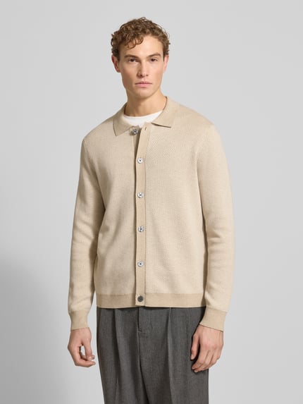 Męski model nosi Strickjacke mit Knopfleiste od Christian Berg Men w kolorze beżowym z bawełny, regular fit, widok całej sylwetki z przodu.
