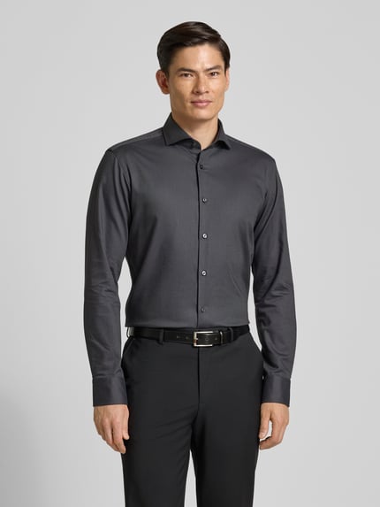 Männermodel trägt Regular Fit zakelijk overhemd aus katoenmix Modell 'H-JOE-SPREAD' van BOSS in effen kleuren, ganzkörperansicht von vorne.