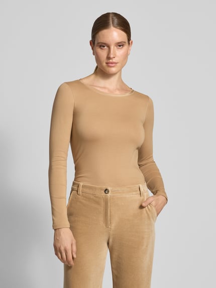 Frauenmodel trägt Slim Fit Langarmshirt aus Baumwoll-Mix von Marc Cain in Beige mit U-Boot-Ausschnitt, Logo-Stickerei, Ganzkörperansicht von vorne. Rückenlänge bei Größe 36: 58 cm, elastisches Material, glatte Struktur.