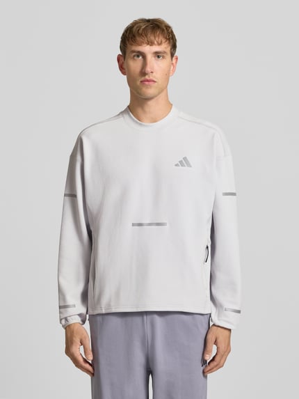 Männermodel trägt Regular Fit Sport-Langarmshirt mit Lyocell-Anteil von adidas Training in Hellgrau, glatte Oberfläche, Ganzkörperansicht von vorne.