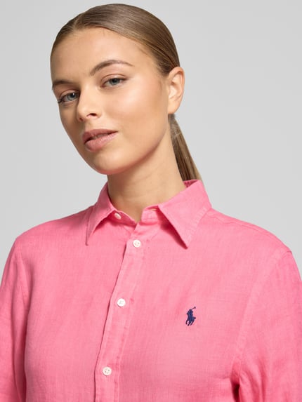Vrouwenmodel draagt Hemdbluse mit Knopfleiste van Polo Ralph Lauren in roze linnen met knoopsluiting, label-stitching, relaxte pasvorm, Nahaufnahme bovenlichaam.