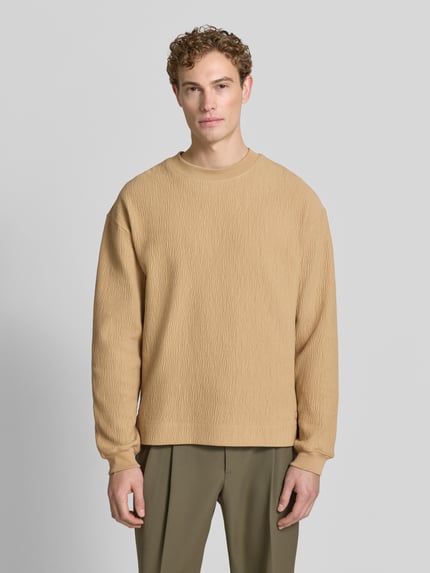 Męski model nosi Regular Fit Sweatshirt aus Baumwoll-Mix Modell 'DENOLONG' von HUGO, beżowa faktura, krój regular fit, Ganzkörperansicht von vorne.