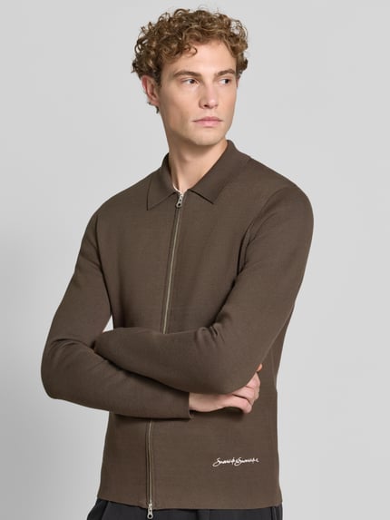Männermodel trägt Regular Fit Jacke aus Viskose-Mix Modell 'Matt' von Samsøe Samsøe in Braun mit Polokragen und Logo-Stitching, Nahaufnahme Oberkörper. Elastischer Stoff, Zweiwege-Reißverschluss, Kontext: Rückenlänge 70 cm, Ärmellänge 68 cm.