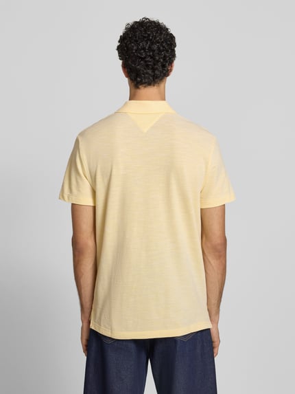 Männermodel draagt Regular Fit poloshirt uit puur katoen van Tommy Hilfiger met melangelook, korte mouw, logostitching, polokraag, V-hals, heren. Ganzkörperansicht Rückansicht.