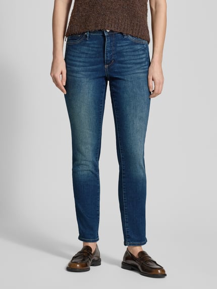 Vrouwenmodel draagt Slim Fit Jeans uit katoenmix model 'BETSY' van s.Oliver RED LABEL in denimlook met contrastnaden, 5-pocket, mid waist, knoopsluiting en labelpatch. Volledige lichaamsaanzicht van voren.