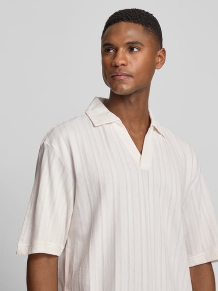 Männermodel trägt Relaxed Fit Poloshirt mit Strukturmuster Modell 'DALIBO' von HUGO in Optik: Unifarben, V-Ausschnitt, reine Baumwolle, Nahaufnahme Oberkörper.