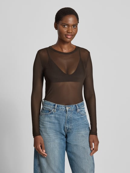 Vrouwenmodel draagt transparant bruin shirt met lange mouwen, ronde hals, losse blue jeans, Slim Fit Langarmshirt mit Rundhalsausschnitt Modell 'LOVA' van VERO MODA, Dames, frontale halve lichaamsopname.