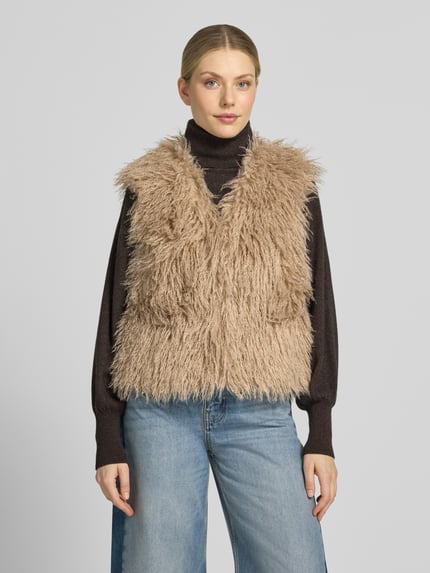 Frauenmodel trägt Weste mit V-Ausschnitt und verdecktem Verschluss von Smith and Soul, Faux Fur, beige Farbe, gerader Schnitt, Ganzkörperansicht von vorne.