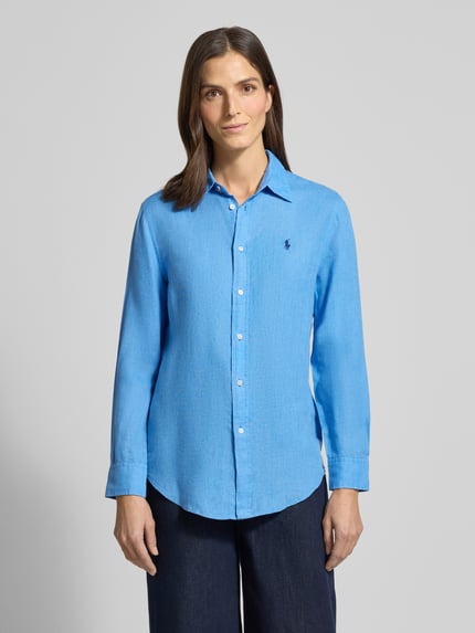 Vrouwenmodel draagt Overhemdblouse met knoopsluiting van Polo Ralph Lauren, zuiver linnen, los model, overhemdkraag, labelstitching, blauwe kleur, ruglengte bij maat S 70 cm, mouwlengte 58 cm, voorkantaanzicht van het hele lichaam.