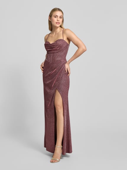 Frauenmodel trägt Abendkleid mit rückseitiger Schnürung von Luxuar, schimmernde A-Linie, Maxikleid mit Gehschlitz, Ganzkörperansicht von vorne.