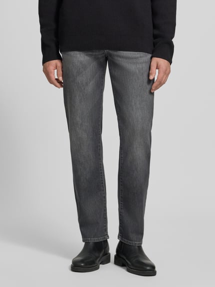Männermodel trägt Relaxed Fit Jeans aus Baumwoll-Mix Modell 'Clint' von Brax in Grau, Herren Wide & Loose Fit Jeans, Ganzkörperansicht von vorne.