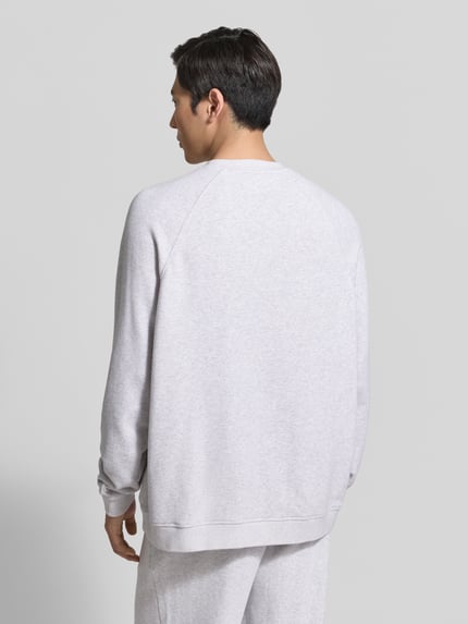 Männermodel trägt Sweatshirt mit Rundhalsausschnitt Modell 'ATUBAY' von American Vintage aus Baumwoll-Elasthan-Mix in Hellgrau, Relaxed-Fit, Rückenansicht, Kontext: Herren Sweatshirt, Rückenlänge bei Größe M/L 67 cm, Ärmellänge 77 cm.