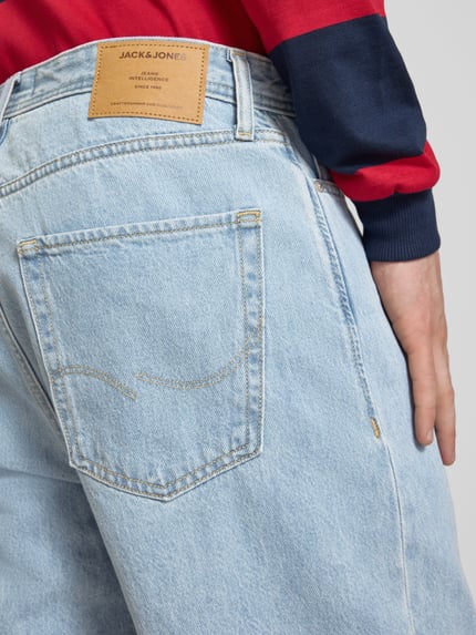 Männermodel trägt Baggy Fit Jeansshorts mit Eingrifftaschen Modell 'ALEX' von Jack & Jones, helle Baumwolle, Detailaufnahme Rückansicht.
