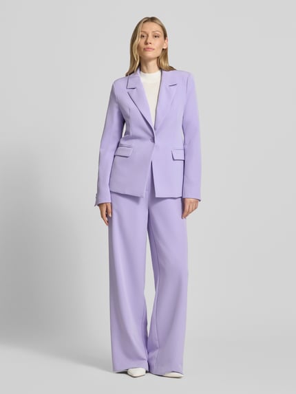 Frauenmodel trägt Slim Fit Blazer mit Pattentaschen Modell 'Isa' von GUIDO MARIA KRETSCHMER WOMAN, Fliederfarbe, Material-Mix mit Stretch-Anteil, Reverskragen, Knopfverschluss, Ganzkörperansicht von vorne.