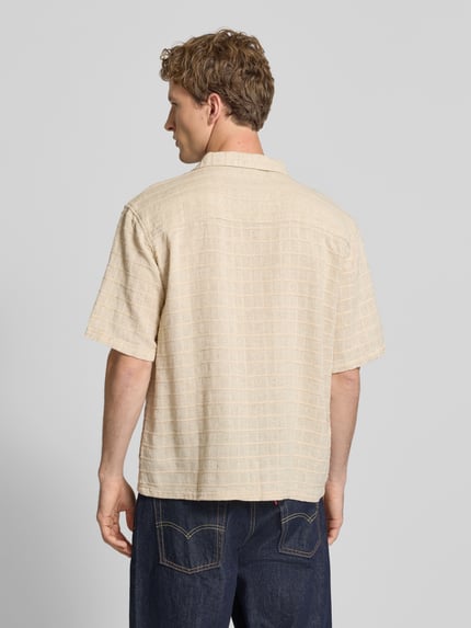 Männermodel trägt Oversized Freizeithemd mit Strukturmuster Modell 'Corey' von Redefined Rebel im Beige-Ton, Leinen-Baumwoll-Mix, Ganzkörperansicht Rückansicht.