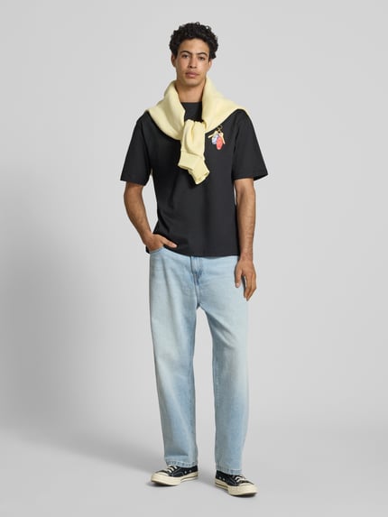 Männermodel trägt Boxy Fit T-Shirt aus reiner Baumwolle Modell 'FRED ESCAPE' von Only & Sons, Optik: Unifarben, Passform: Boxy-Fit, Motiv-Print, Rundhals, Ärmelform: Kurzarm, Materialverarbeitung: Jersey, Herren T-Shirt, Ganzkörperansicht von vorne.