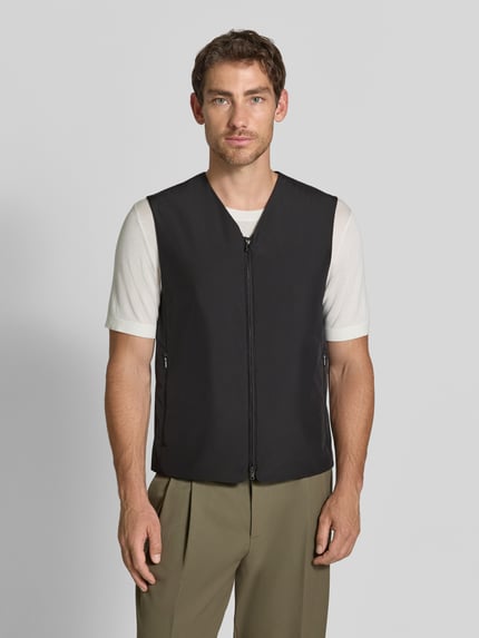 Männermodel trägt Regular Fit Weste mit V-Ausschnitt Modell 'Marve' von Tiger of Sweden in Schwarz mit Zweiwege-Reißverschluss, Ganzkörperansicht von vorne. Rückenlänge 63 cm, Schulterbreite 41 cm, Brustweite 52 cm, Eingrifftaschen mit Reißverschluss, glatte Textur.