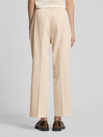 Frauenmodel trägt Straight Fit Stoffhose aus Leinen-Mix von Christian Berg Woman Selection in Beige mit Bügelfalten und Gesäßtasche, Ganzkörperansicht Rückansicht.