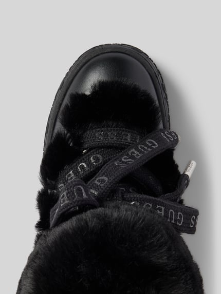 Produktfoto, schwarze Schnürschuhe mit Kunstfellbesatz und Logo-Detail Modell 'Uneek' von Guess, abgerundete Form, profilierte Sohle, Detailaufnahme