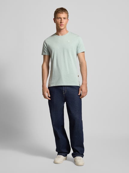 Mannenmodel draagt Regular Fit T-shirt uit puur katoen van G-star in melangelook met labelpatch, ronde hals, korte mouw, jersey, ruglengte maat M 74 cm, borstwijdte 53 cm, full body vooraanzicht.