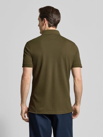 Männermodel trägt Regular Fit Poloshirt aus Baumwoll-Mix von Tommy Hilfiger in Oliv, Optik: Unifarben, Ganzkörperansicht Rückansicht.