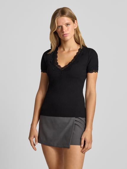 Frauenmodel trägt T-Shirt in Ripp-Optik mit Spitzenbesatz von Gina Tricot, Schwarz, Slim Fit, Baumwoll-Elasthan, Ganzkörperansicht von vorne.