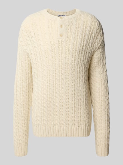Produktfoto, Kabelgestrickter Pullover mit Henley-Kragen von REVIEW in Creme mit Zopfmuster, Regular Fit, Knopfleiste, strukturierte Oberfläche.
