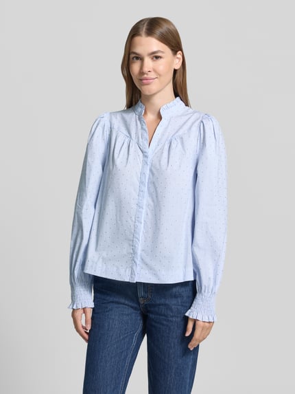 Frauenmodel trägt Regular Fit Bluse mit V-Ausschnitt Modell 'Astrida' von Neo Noir, hellblau mit feinem Streifenmuster, Baumwoll-Mix mit Stretch-Anteil, Stehkragen, lange Ärmel, glatte Textur, Ganzkörperansicht von vorne.