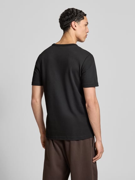 Mannelijk model draagt Regular Fit T-Shirt met katoen van adidas Originals, effen zwart, logo-stitching, wafelstructuur, korte mouw, rond de hals, regular fit, volledig lichaam achteraanzicht.