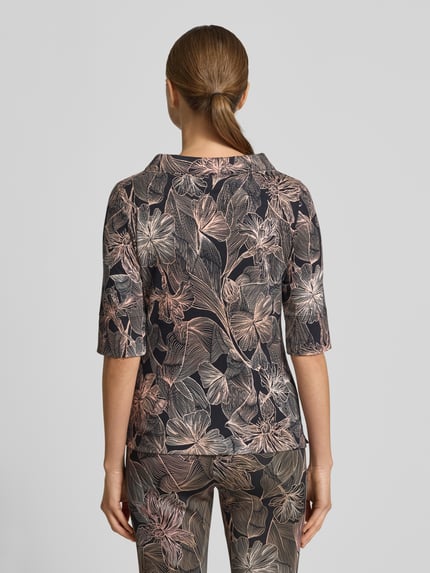 Vrouwenmodel draagt T-Shirt met Stehkragen van Marc Cain, slim fit, katoen-elastaan mix, half lange mouw, bloemenprint, rugaanzicht.