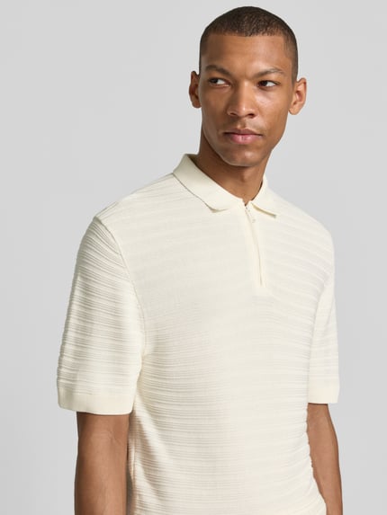 Männermodel trägt Regular Fit Poloshirt mit kurzem Reißverschluss von MCNEAL, Baumwoll-Mix mit Viskose-Anteil, Strukturmuster, Nahaufnahme Oberkörper.