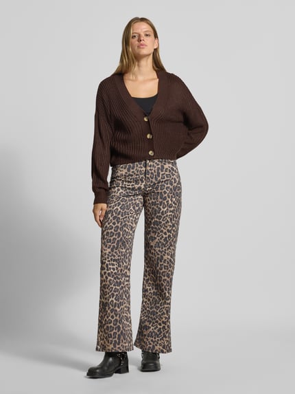 Frauenmodel trägt Boxy Fit Strickjacke mit V-Ausschnitt Modell 'CAROL' von ONLY, braun, grob gestrickt, Ganzkörperansicht von vorne, Damen Strickjacke von ONLY.
