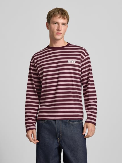 Männermodel trägt Gestreiftes Langarmshirt mit Logoprint vorne und hinten von REVIEW, Regular Fit, reine Baumwolle, Ganzkörperansicht von vorne.