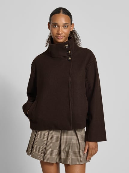 Frauenmodel trägt Regular Fit Blouson mit Stehkragen Modell 'GNES' von PIECES, dunkelbraune Farbe, glatte Textur, karierter Rock, Nahaufnahme Oberkörper, Damen Bomberjacke / Blouson von PIECES.