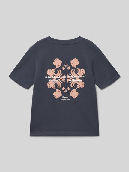 Junge trägt dziecięcy t-shirt z bawełny Jack & Jones, prosty krój, okrągły dekolt, nadruk z motywem na plecach, model 'MONTAUK', długość tyłu w rozmiarze 140: 52 cm, Ganzkörperansicht Rückansicht.